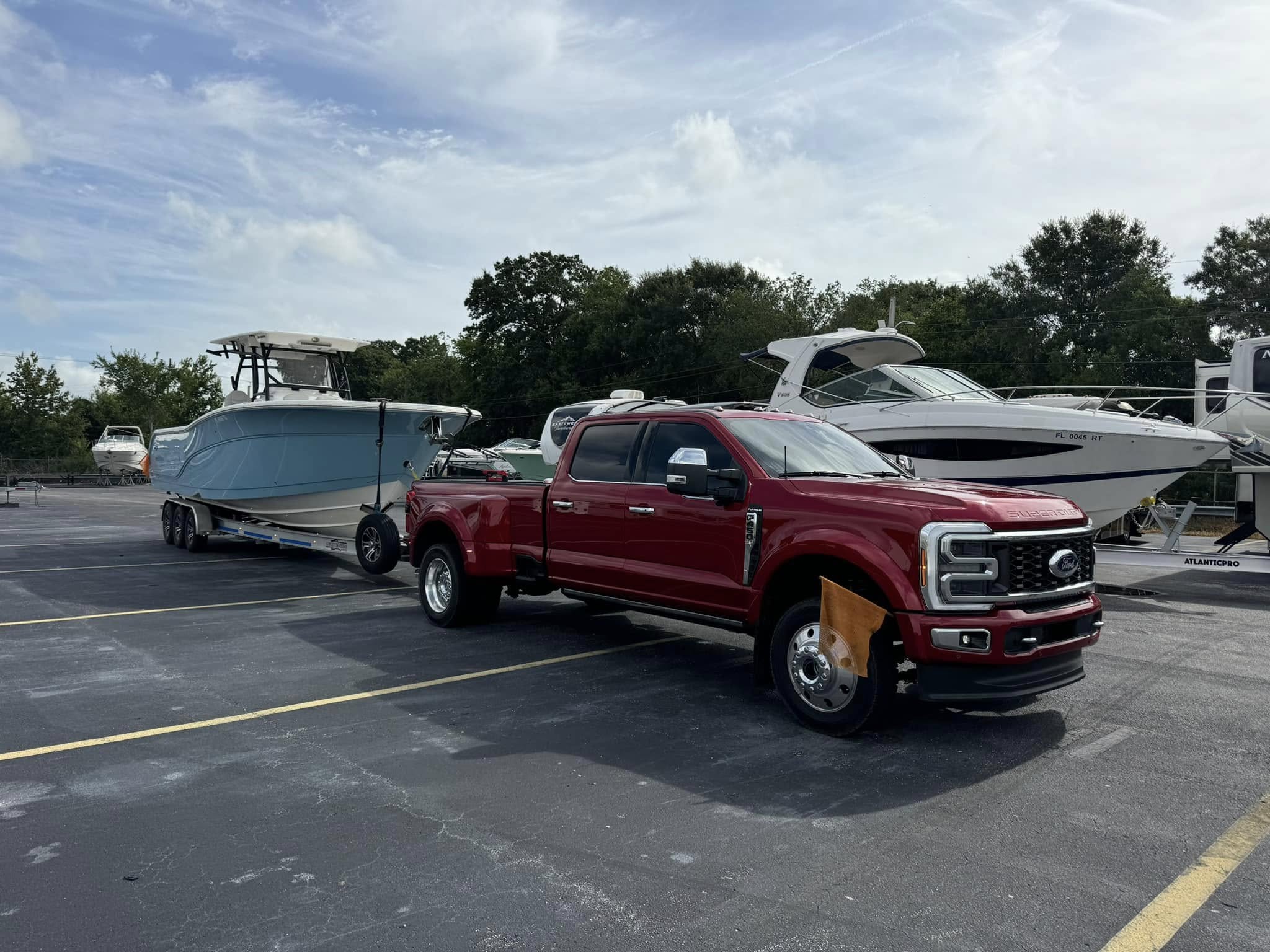 Ford F-450 dually towing a center console boat on a trailer for transport in Southwest Florida