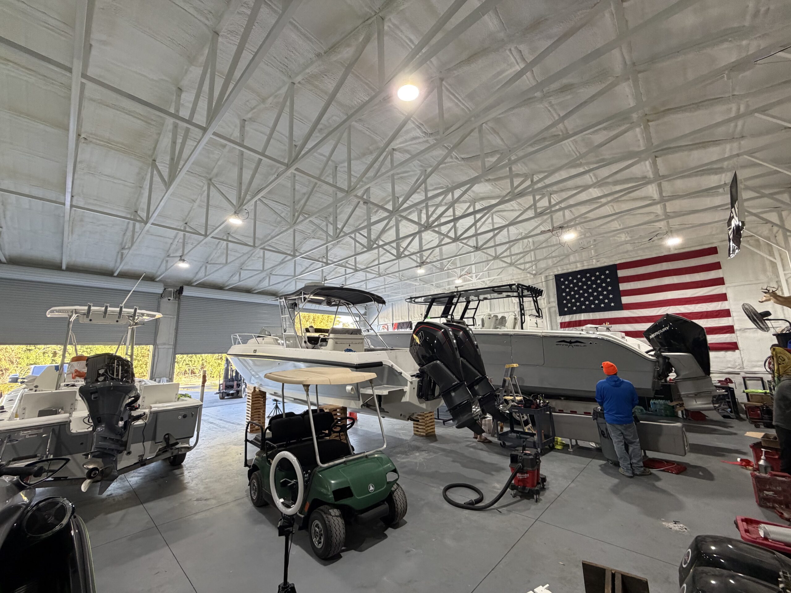 Gray center console boat on a trailer inside a Deluxe Marine facility in Southwest Florida