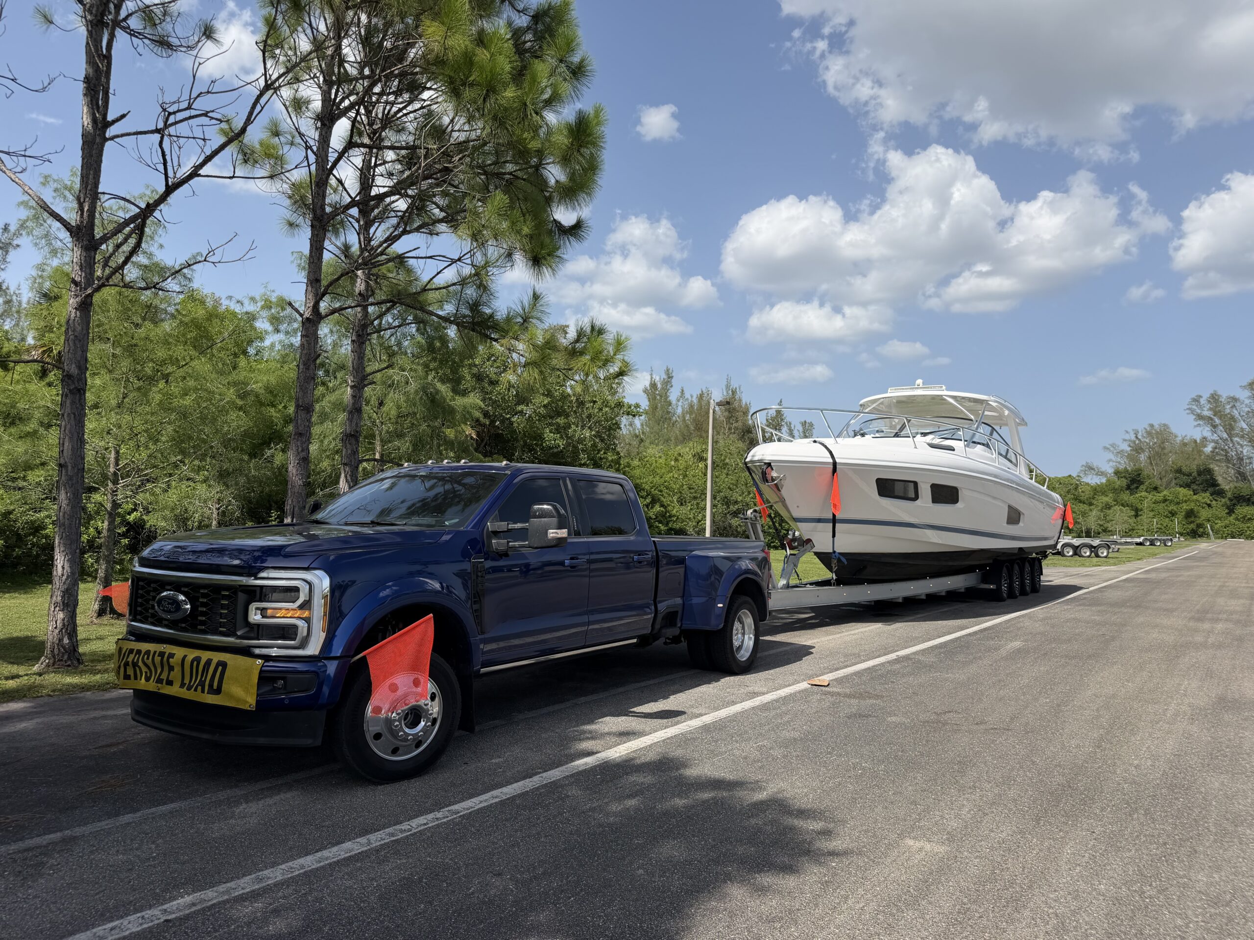 Ford F-450 dually towing a center console boat on a trailer for transport in Southwest Florida