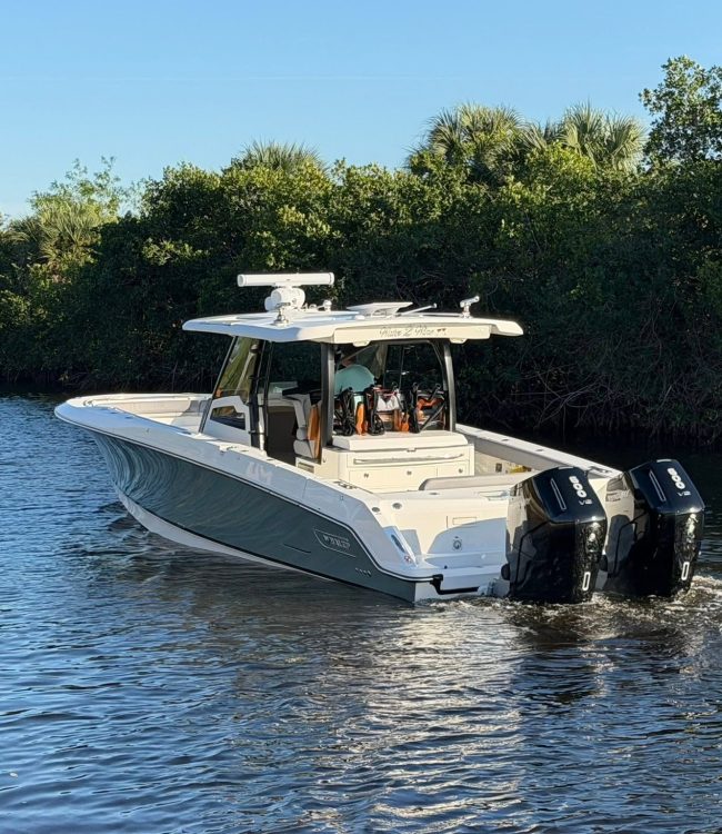 Deluxe Marine-serviced Boston Whaler center console with twin Mercury 300 V8 outboards cruising a SWFL waterway