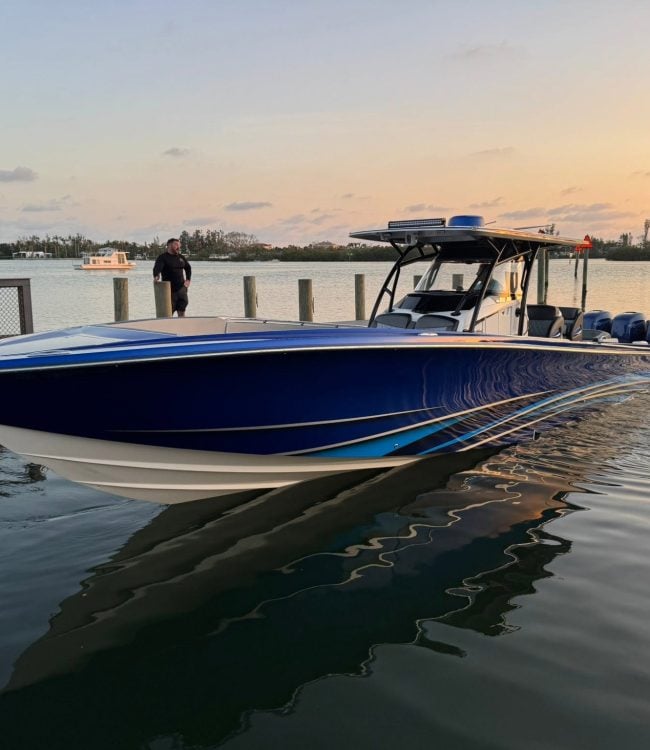 Blue center console with quad Mercury 400 outboards idling at a dock at sunset in Southwest Florida
