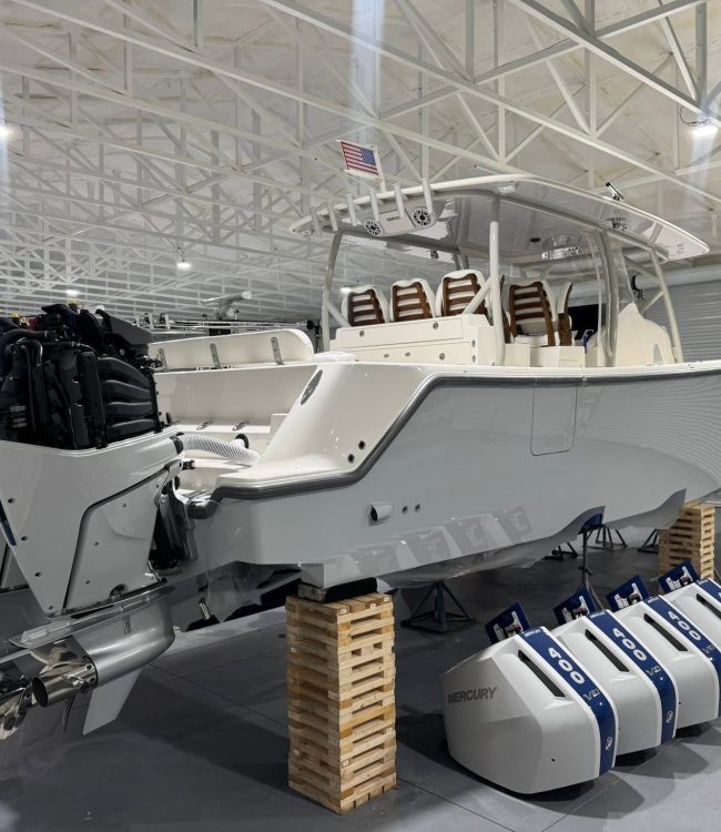 White center console with quad Mercury 400 outboards mid-repower and cowlings staged in a Southwest Florida shop