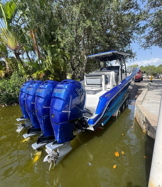 Blue center console with quad Mercury Racing 400R outboards at a boat ramp in Southwest Florida