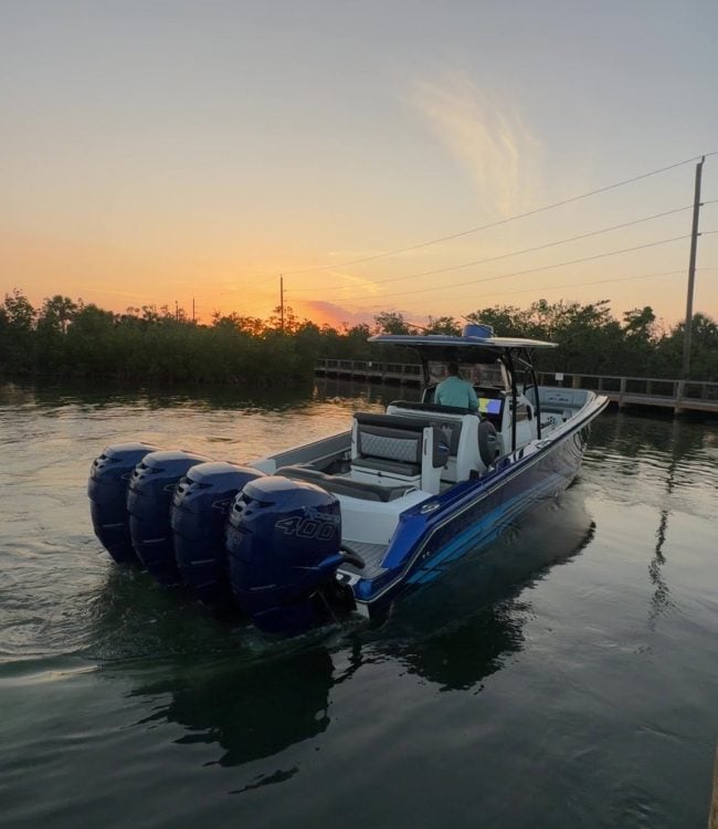 Blue center console boat with quad Mercury Racing 400 outboards on the water at sunset in Southwest Florida